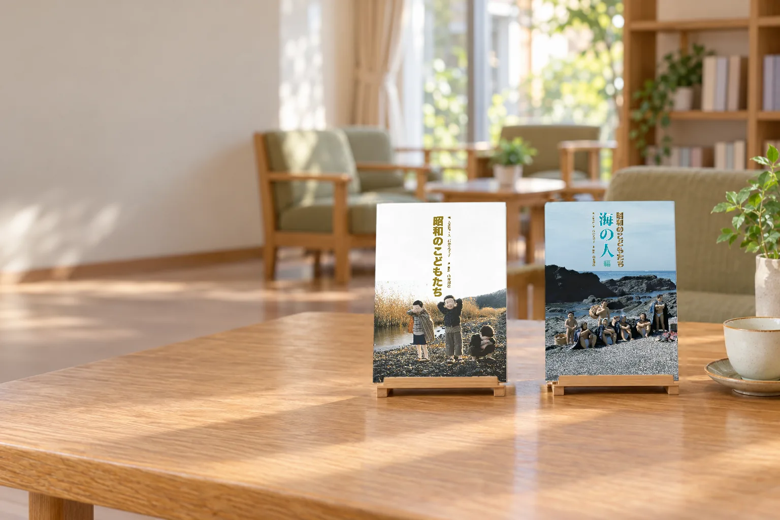 明るい部屋の机の上に立てた、写真集『写真物語 昭和のこどもたち』のふるさと編と海の人編(イメージ)